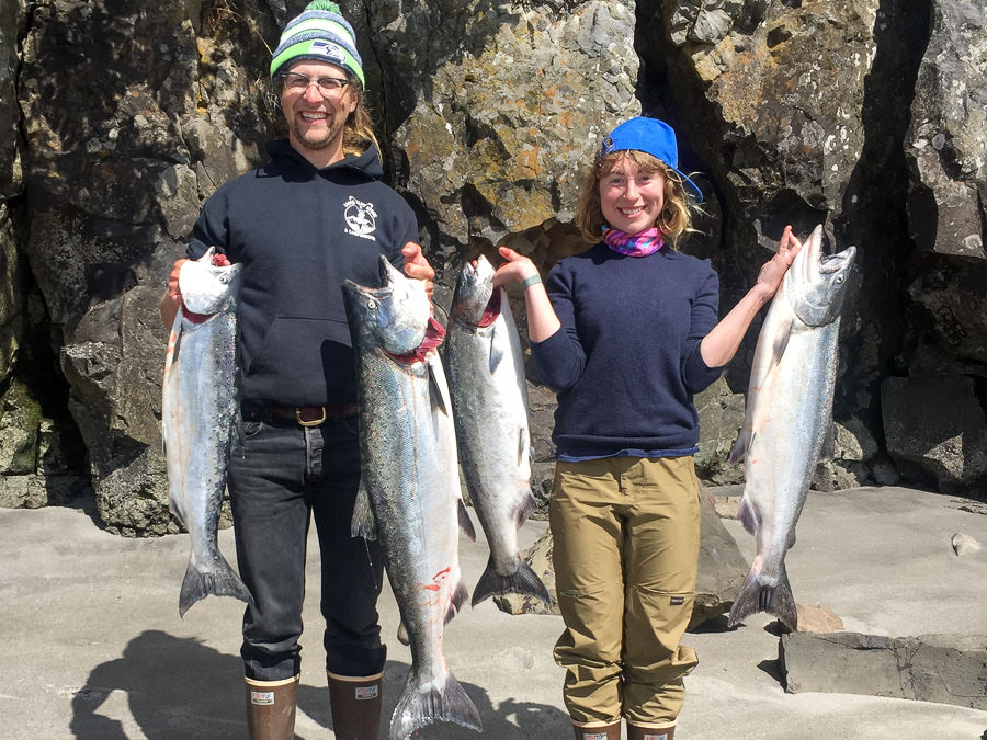 Astoria Columbia river fishing guide clients hold their catch of Fall chinook salmon on the river bank