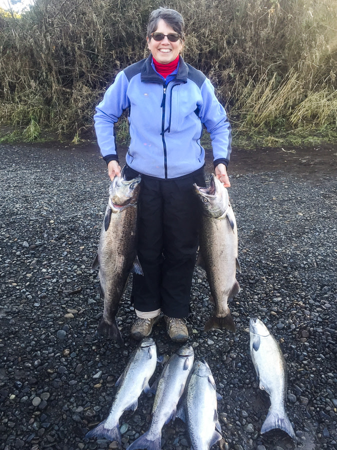 Woman holds limit of Fall Chinook Salmon she caught on the Trask River