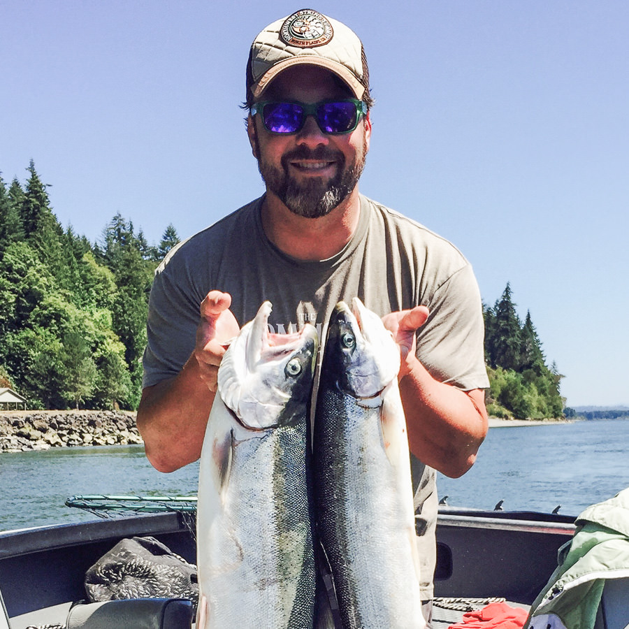 Man holds up two summer steelhead caught on the Columbia River with Oregon fishing guide Mike Hazen