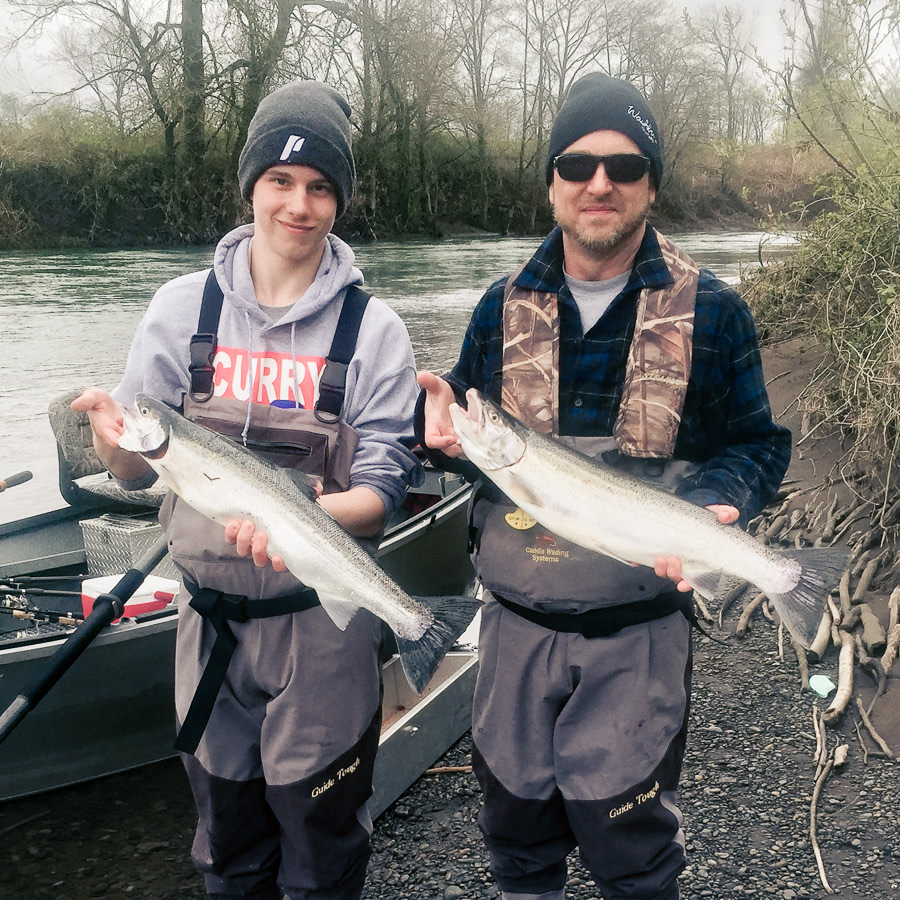 Father and son hold up their winter steelhead caught on the Wilson River in Tillamook with an Oregon fishing guide