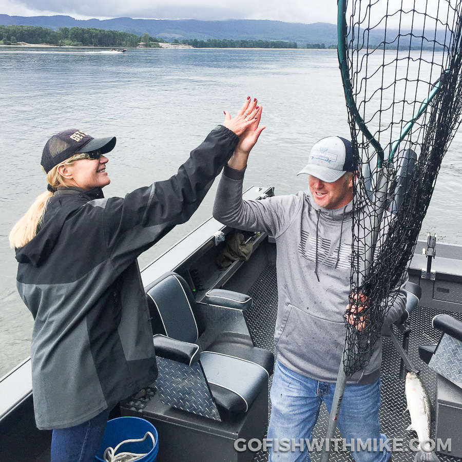Fishing guide Mike hazen high fives his clients after catching a summer steelhead on the Columbia