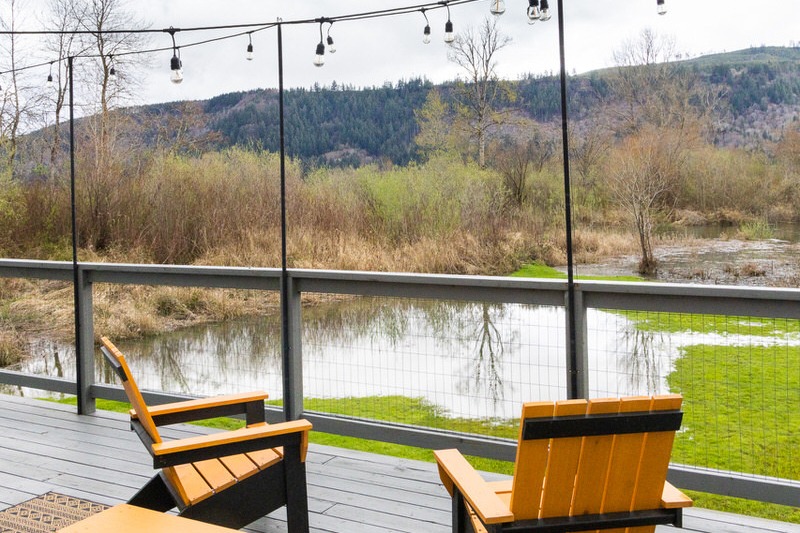 Fishing cabin on Puget Island, Washington in Cathlamet. Waterfront property deck overlooking the Columbia River with Adirondack chairs