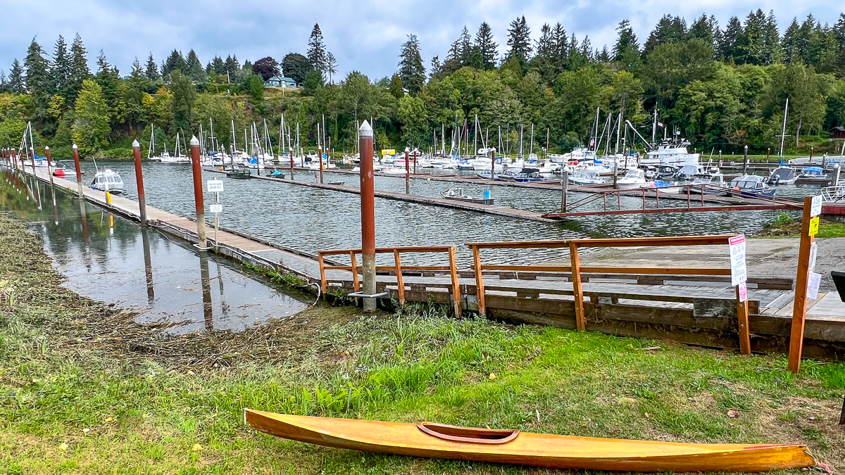 Elochoman Slough Marina in Cathlamet Washington. Boat ramp to launch boats for duck hunting. Sailboats in the background and wooden kayak in the foreground.